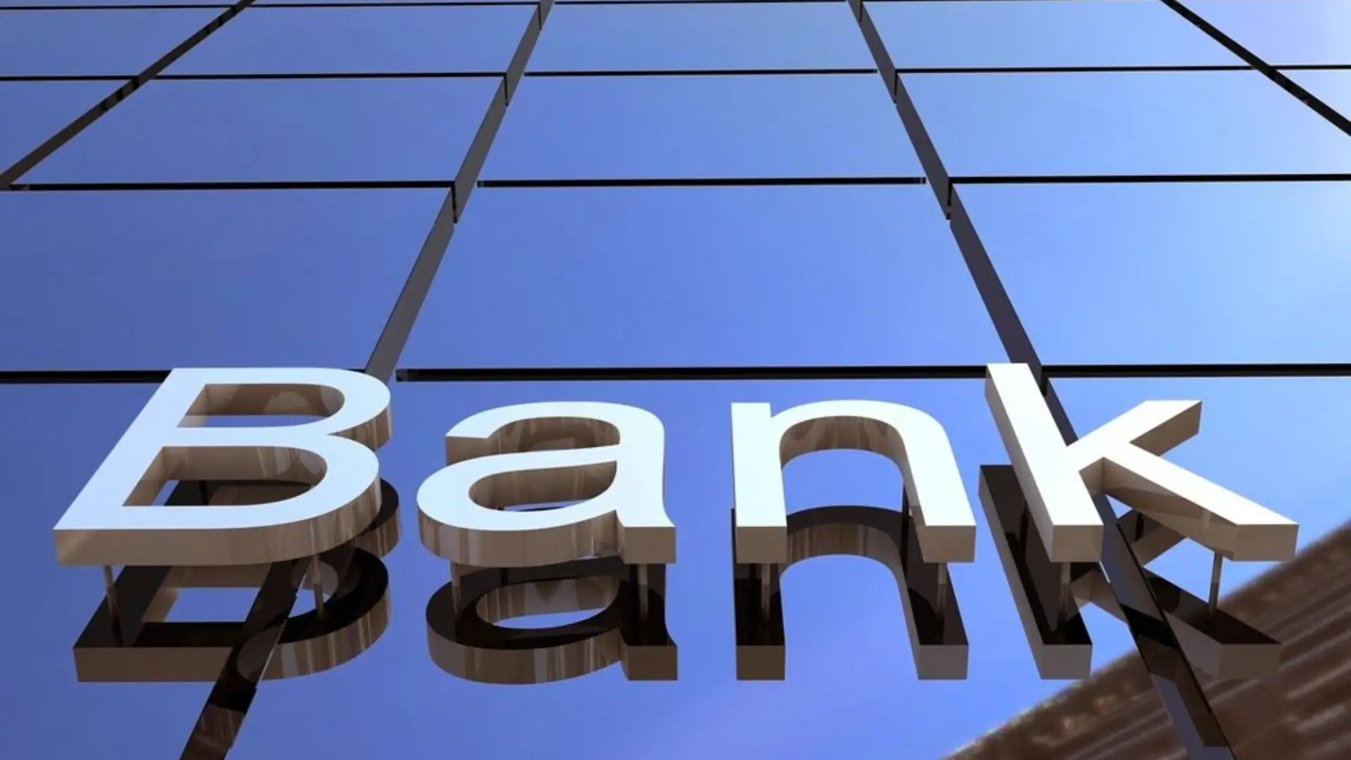 High‑rise building with reflective glass panels and large three‑dimensional white letters spelling “Bank,” symbolizing financial institution.