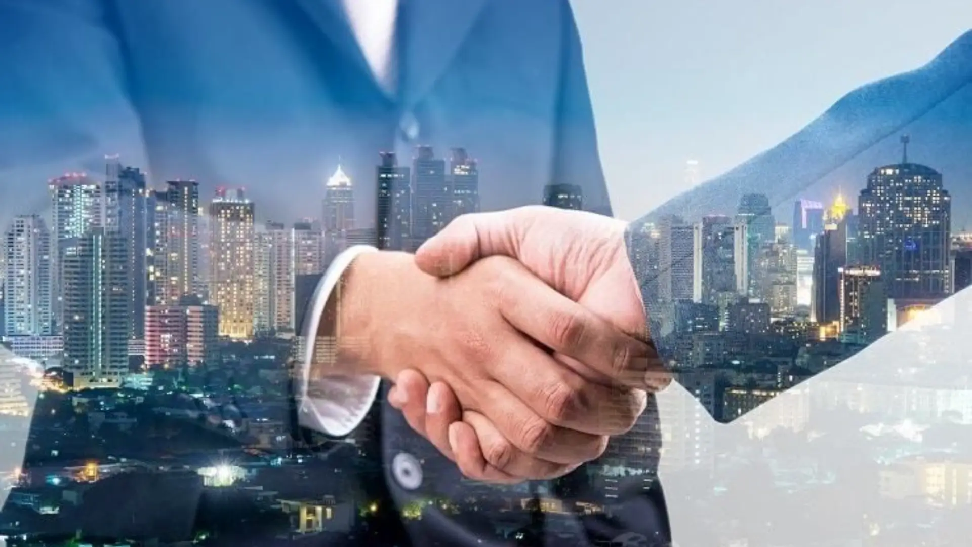 Two business professionals shaking hands with a cityscape background, symbolizing partnership and collaboration.